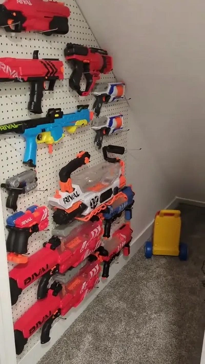 nerf guns organized on a pegboard on the left