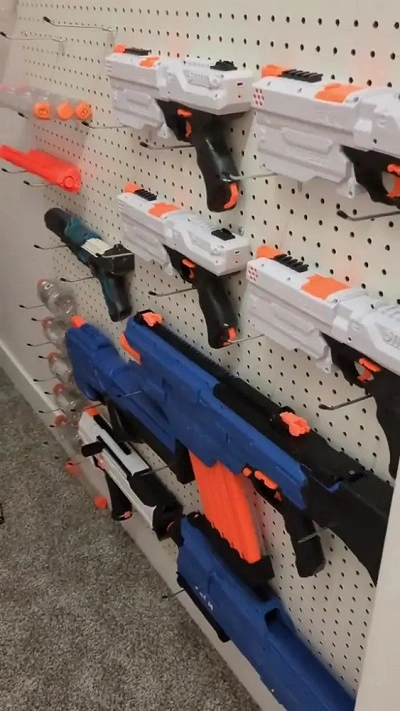 nerf guns organized on a pegboard on the right